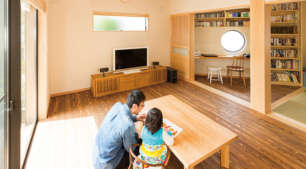 リビングで絵本を読む親子