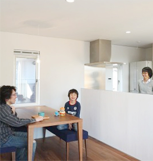 一戸建て住宅のリビングでくつろぐ家族